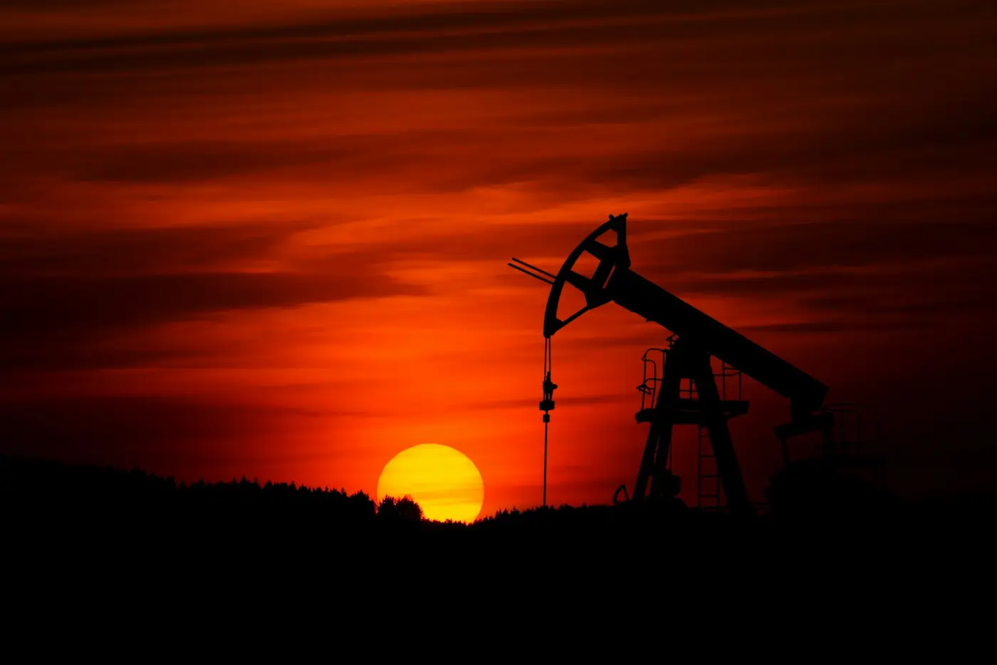 Pumpjack silhouetted against a prairie sunset